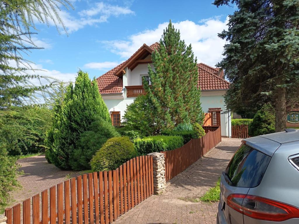 a fence in front of a house with trees at Rezidence Jih in Hlavňovice