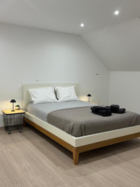 a white bedroom with a large bed with two lamps at Chambre Élégance et confort a Esch in Esch-sur-Alzette