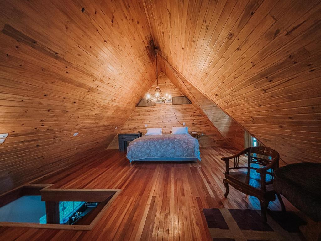 een slaapkamer met een bed op een houten zolder bij Vila Gramado in Gramado