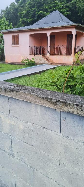 a brick retaining wall in front of a house at Acomatsalon in Pointe-Noire