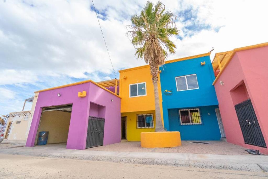 a row of colorful houses with a palm tree in front at Condo 5, in San Felipe Just Steps to the Beach, Near the Malecon. in San Felipe