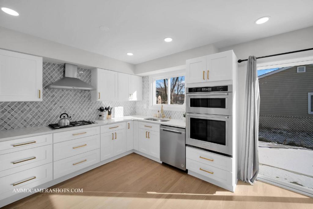 a white kitchen with white cabinets and a window at Chicago Gem! Centrally Located - proximity to O' Hare Airport in Schaumburg