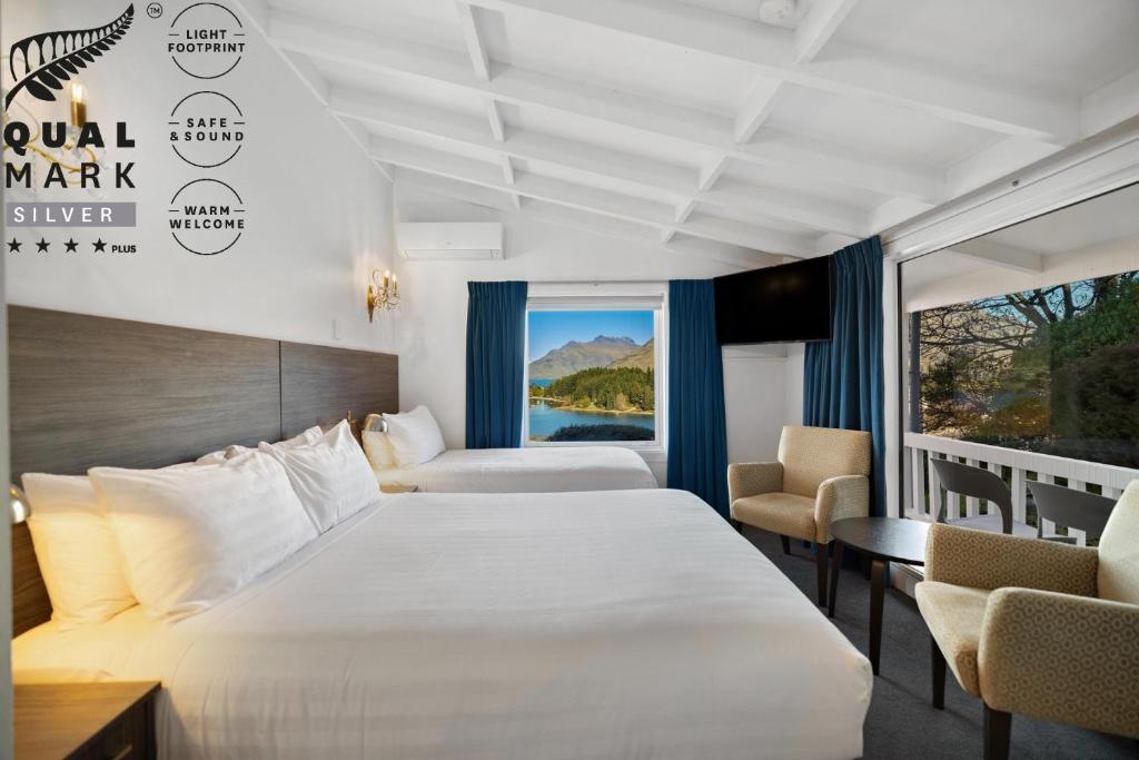 クイーンズタウンにあるLakeview Colonial Motelのベッドとバルコニー付きのホテルの部屋