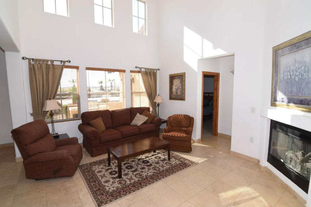 a living room with a couch and chairs and a fireplace at El Dorado Ranch Vacation Rental Condo 25-1 | 18-Hole Golf in Playa El Paraíso