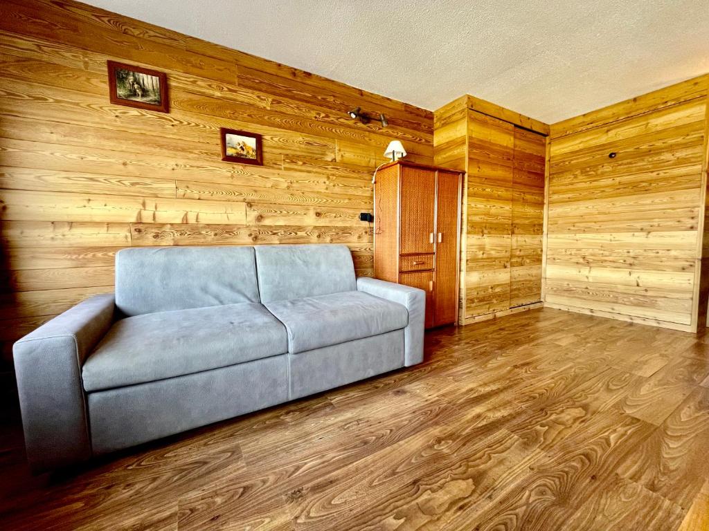 a couch in a living room with wooden walls at Ski&Sky Studiò 85 in Pila