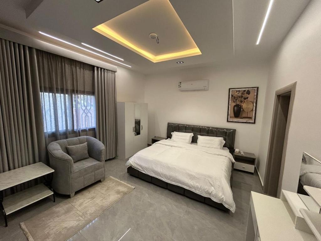 a large bedroom with a bed and a chair at قمرة قباء Quba moon5 in Al Madinah