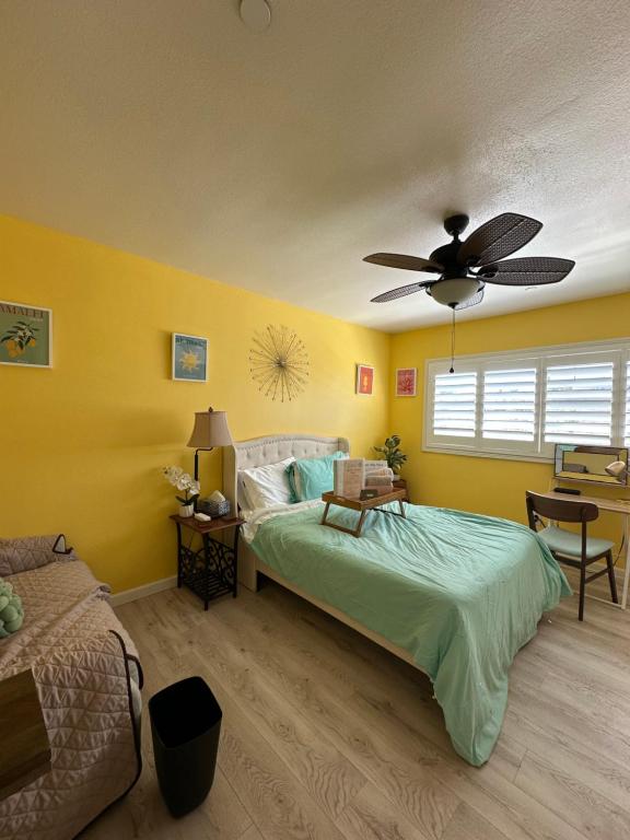 a bedroom with a bed and a ceiling fan at Yellow Cactus Oasis in White Water