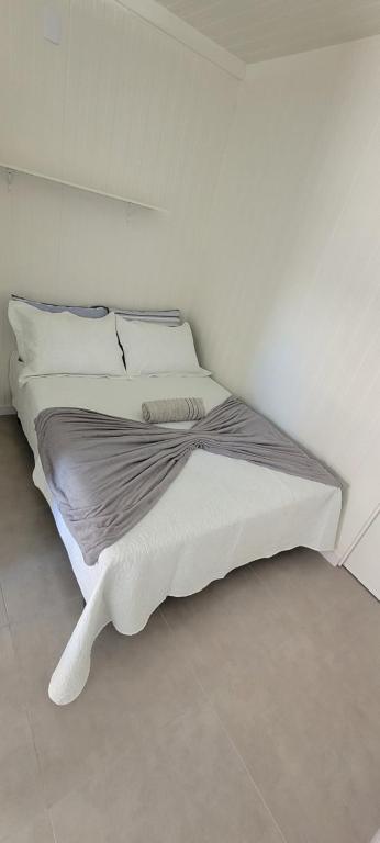 a white bed in a white room with at Refúgio ensolarado a poucos passos do mar in Navegantes