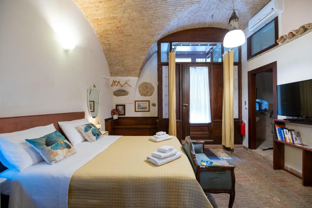 a bedroom with a large bed and a tv at L'Alcova dei Grifoni in Ascoli Satriano