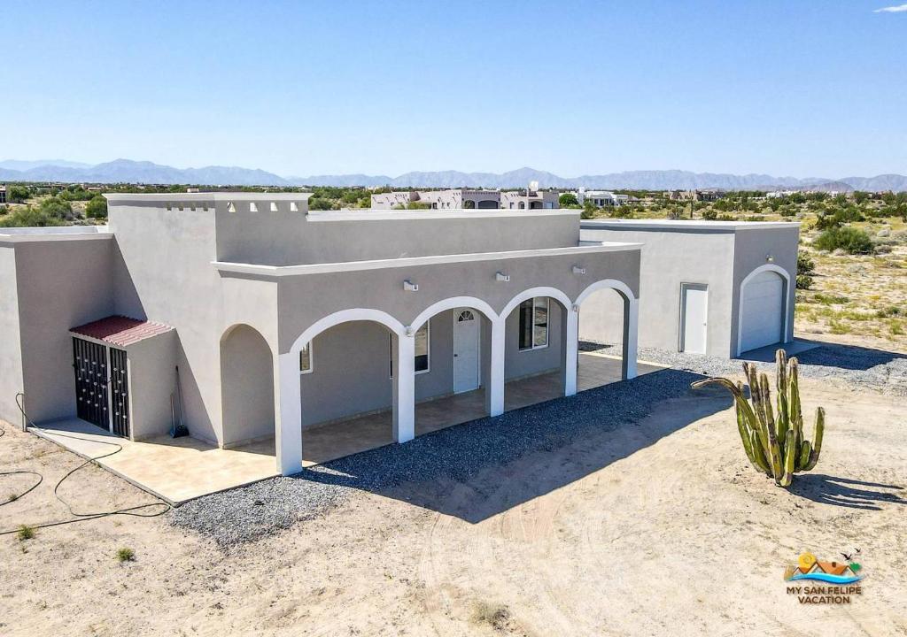 a white house in the middle of the desert at Casa Desert Rose - Gated Community San Felipe Vacation Rental Home in Playa Hawaii