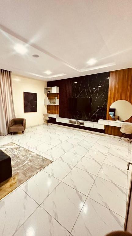 イケジャにあるSerenity Villa Ikejaの白いタイルフロアの広いリビングルーム