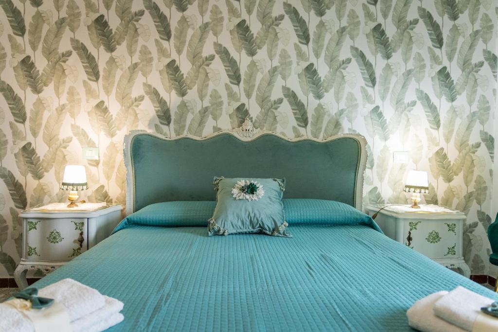 Un dormitorio con una cama azul con dos mesitas de noche. en Fabiola Guest House, en Pompeya