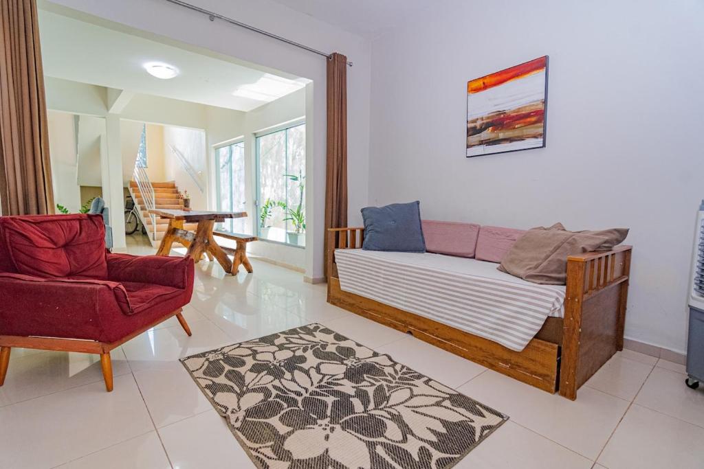 a living room with a couch and a chair at Casa de Verão, 04 quartos, 03 banheiros, piscina e churrasqueira para relaxar in Pirapora