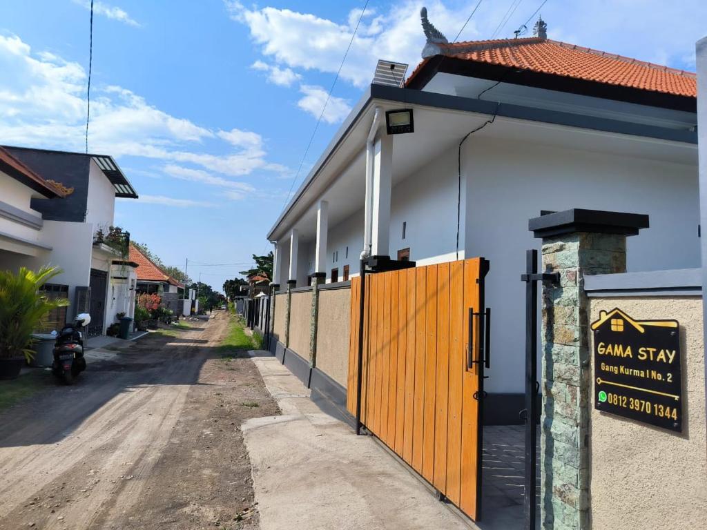 a building with an orange gate next to a street at Gama Stay in Lovina