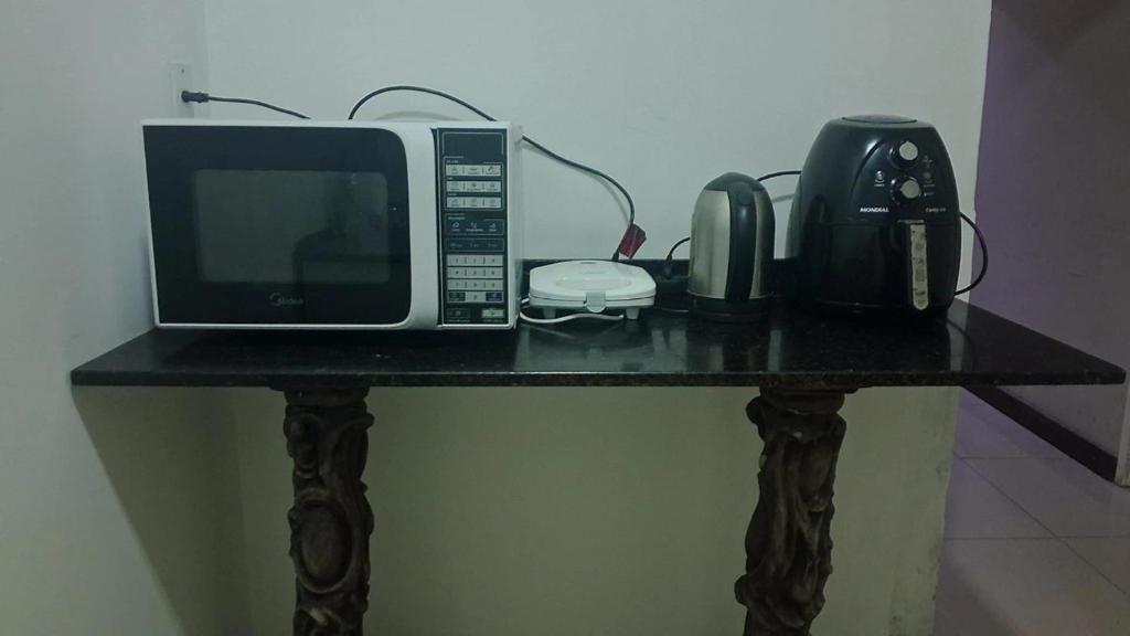 une table avec un micro-ondes et un téléphone dessus dans l'établissement Vida & Brisa, à Pelotas