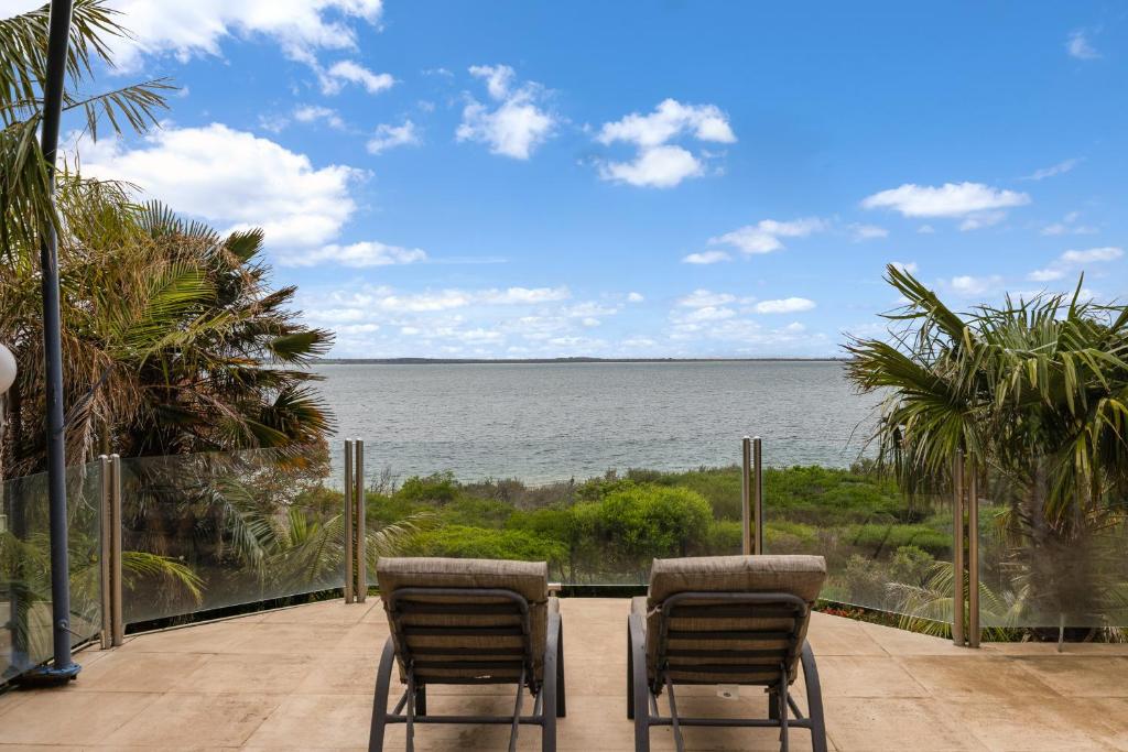 a patio with two chairs and a view of the ocean at Waterfront Seabreeze Cowes in Cowes