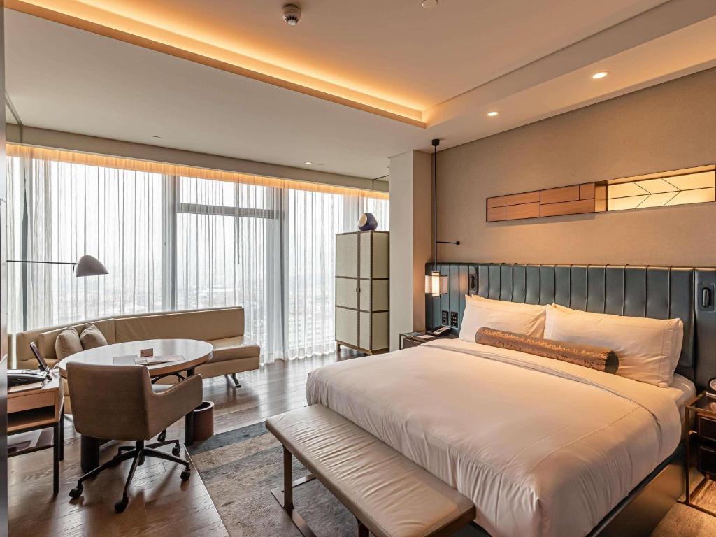 a bedroom with a bed and a desk and a table at Fairmont Quasar Istanbul Hotel in Istanbul