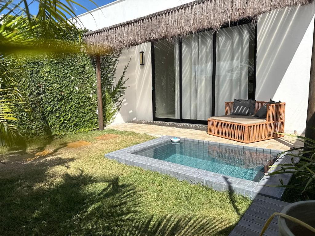 a swimming pool with a chair next to a house at Casa com piscina privativa Praia da Pipa #2 in Tibau do Sul