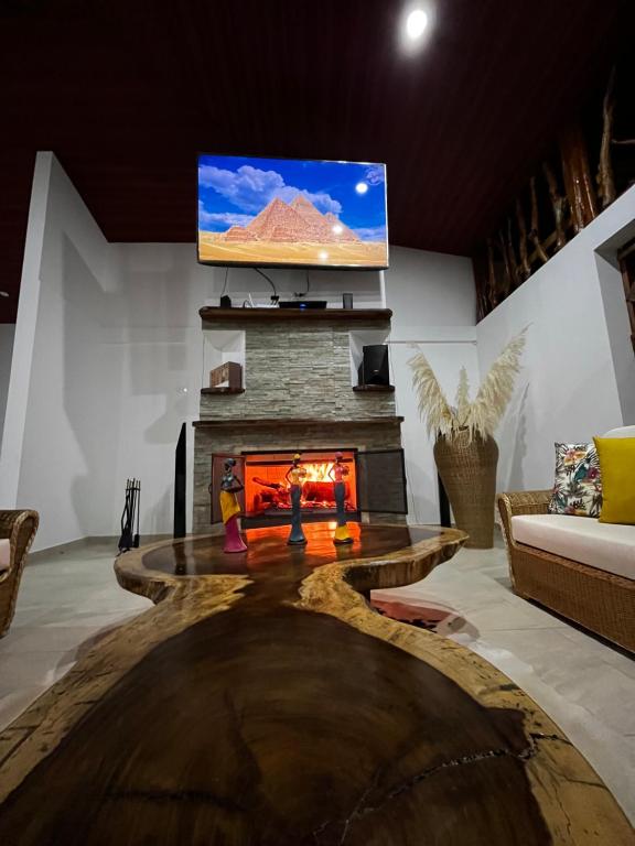 a living room with a fireplace and a flat screen tv at Villa Celeste in Macanal