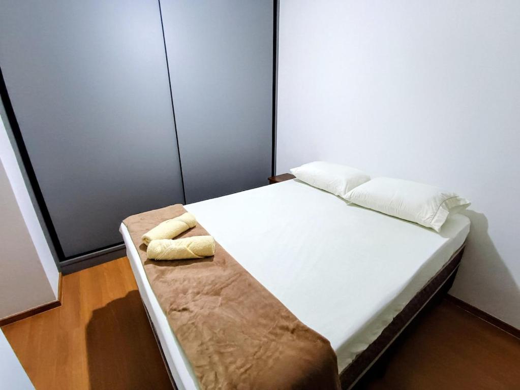 ein Schlafzimmer mit einem großen Bett mit weißer Bettwäsche in der Unterkunft Apartamento aconchegante in Maringá