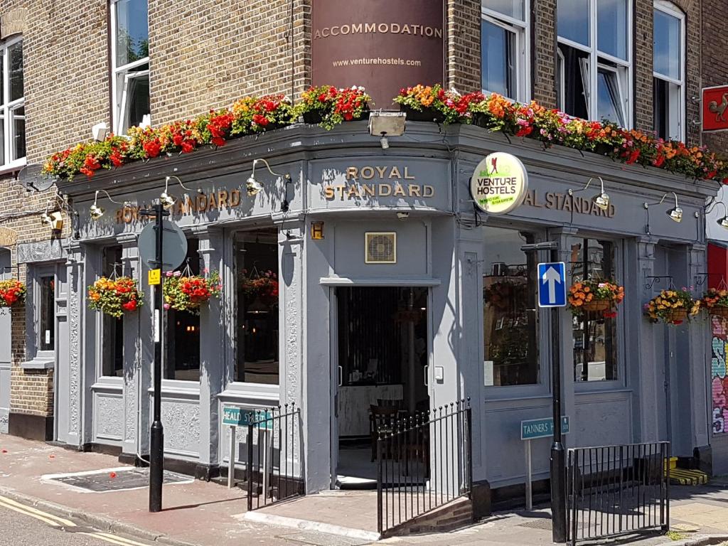 Un bâtiment avec des fleurs à l'avant dans l'établissement Book A Bed Hostels, à Londres