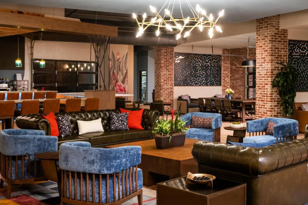 a lobby with couches and chairs and a table at voco College Station Aggieland by IHG in College Station