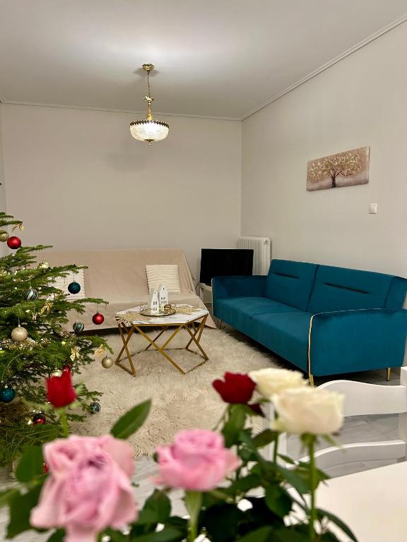 a living room with a blue couch and a christmas tree at Roseberry luxury apartment in Tríkala