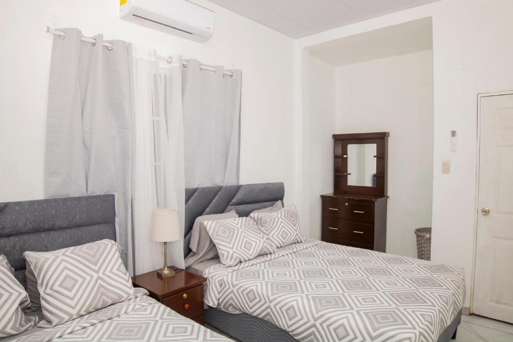 a bedroom with two beds and a dresser at Coco Cabana en Playa San Diego in San Diego