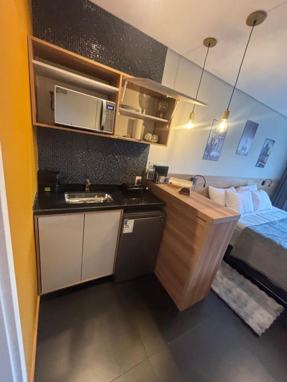 a small room with a kitchen and a bed at Lorde J in Araras Petropolis