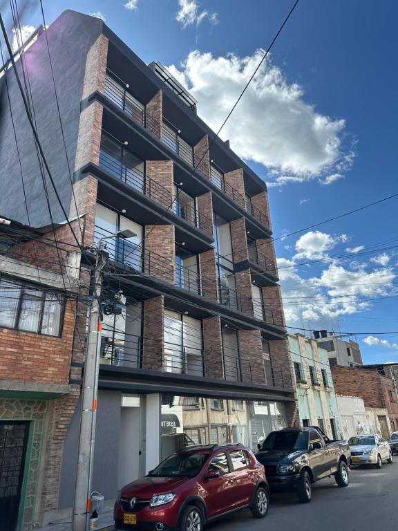 Un coche rojo aparcado delante de un edificio en Apartamento excelente ubicacion, en Sogamoso