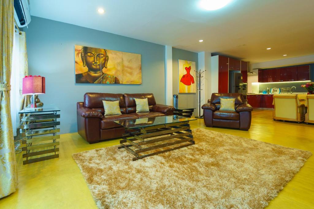 a living room with couches and a coffee table at Luxury Town House in the Heart of the Old City in Chiang Mai