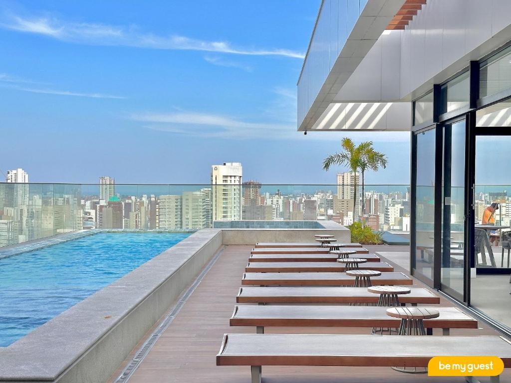 ein Pool mit Bänken und Blick auf die Stadt in der Unterkunft Beach Class Meireles in Fortaleza