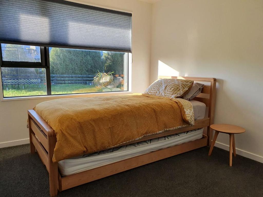 a bedroom with a bed and a large window at Homestead Hideaway in Ohoka in Ohoka