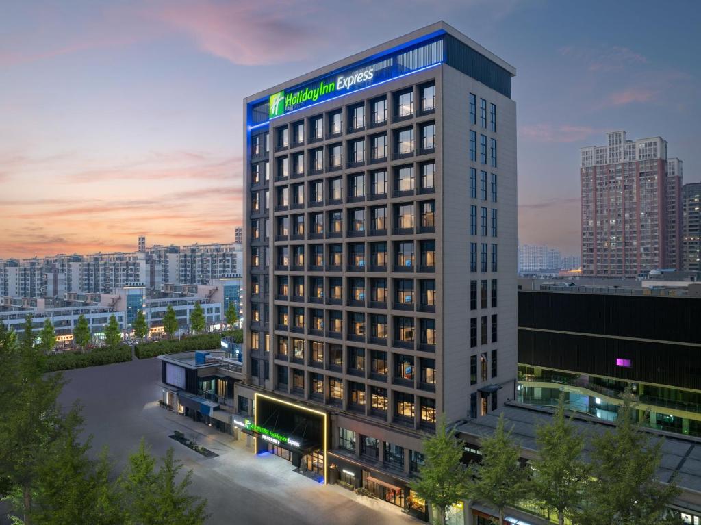 a tall building with a sign on top of it at Holiday Inn Express Changzhou Henglin by IHG in Changzhou