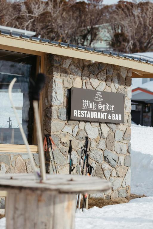 a sign for a ski studio restaurant and bar at Eiger Chalet in Perisher Valley