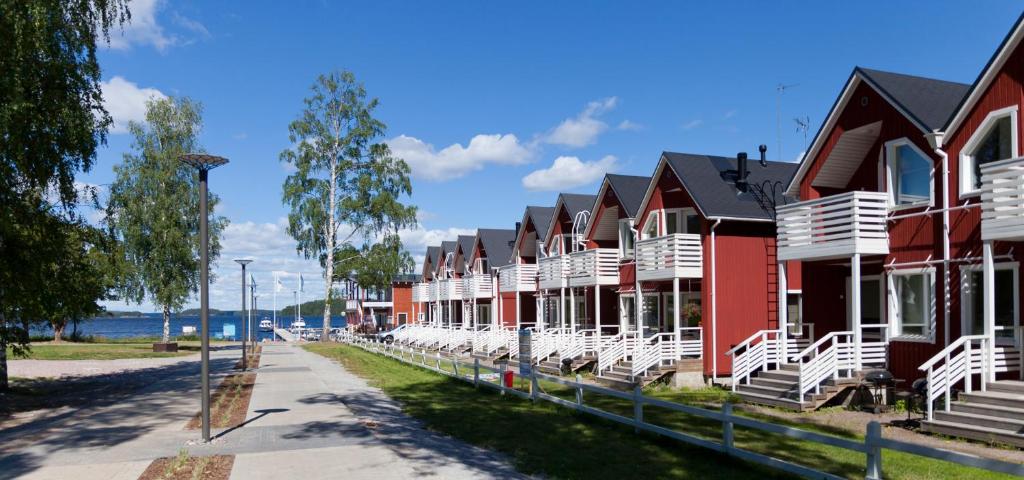 una fila de casas con sillas blancas en una calle en Holiday Houses Saimaa Gardens, en Imatra
