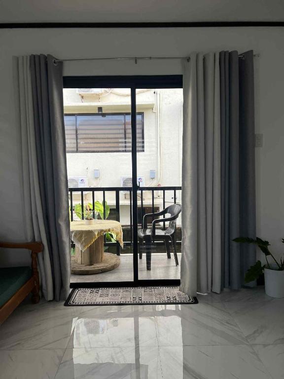 a room with a sliding glass door to a balcony at Xavier's Place Two in Coron