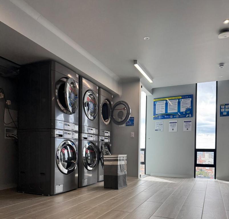 una fila de lavadoras en una lavandería en Modern apartment with a beautiful panoramic view, en Bogotá