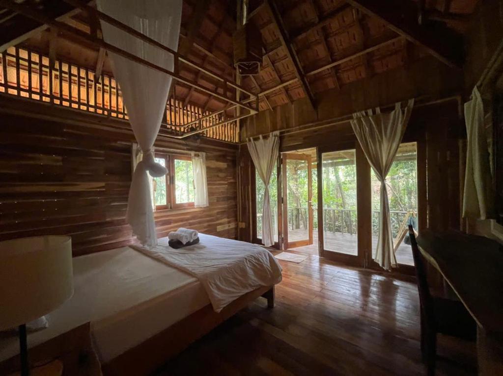 Un dormitorio con una cama en una habitación con ventanas. en Farm House, en Phu Quoc