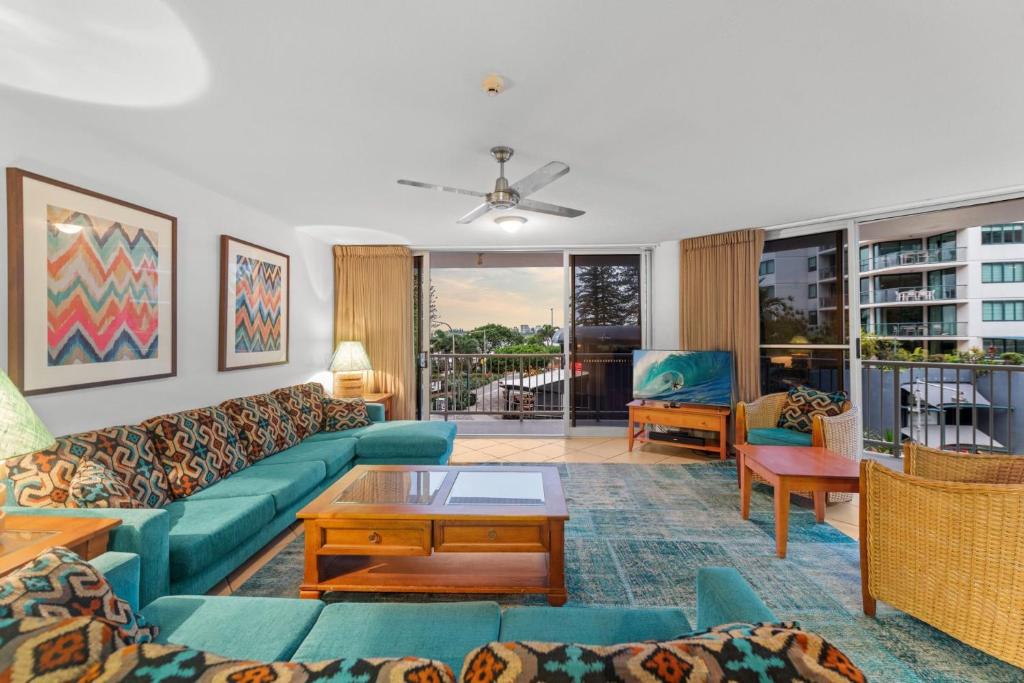 a living room with a couch and a table at Brisbane Road Apartments Mooloolaba in Mooloolaba