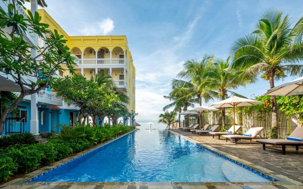 Grace Boutique Resort في موي ني: حمام سباحة في المنتجع مع كراسي ومظلات