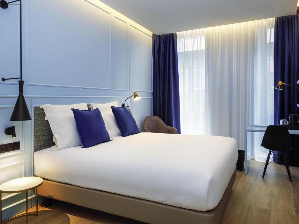 Un pat sau paturi într-o cameră la Mercure Porto Centro Aliados