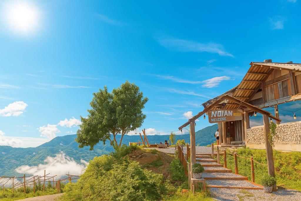 Bắc YênにあるNơi Ấy Homestayの山を背景にした丘の上の小さな建物