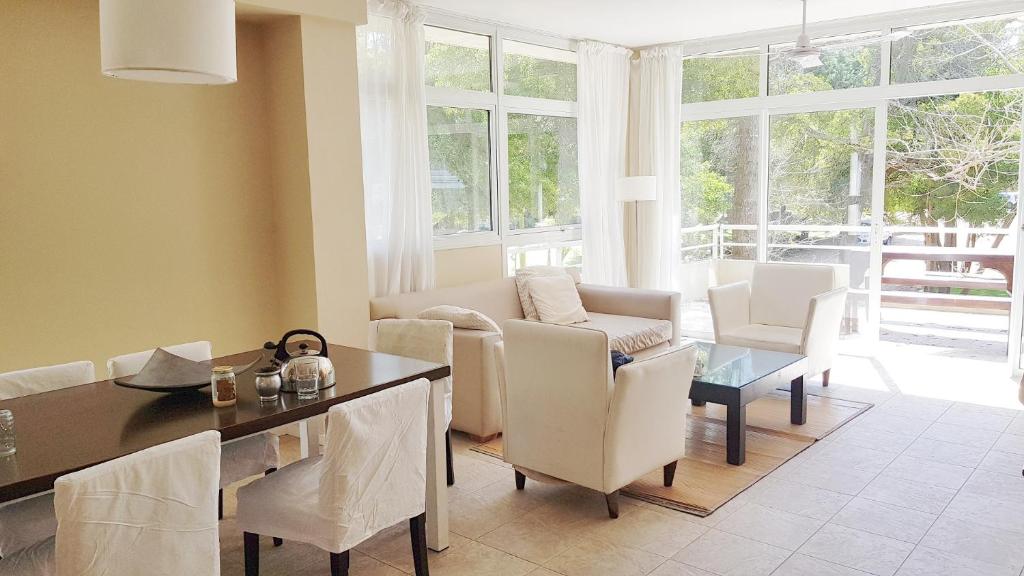 ein Wohnzimmer mit Tisch und Stühlen und einer Couch in der Unterkunft Terrazas de Carilo 1A in Carilo