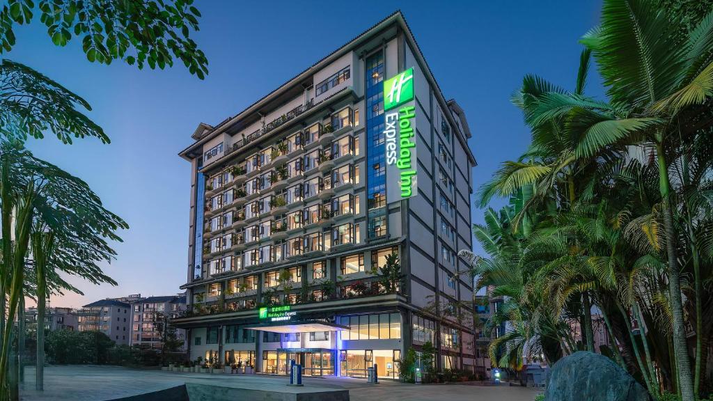 a tall building with a green sign on it at Holiday Inn Express Puer Simao by IHG in Pu'er