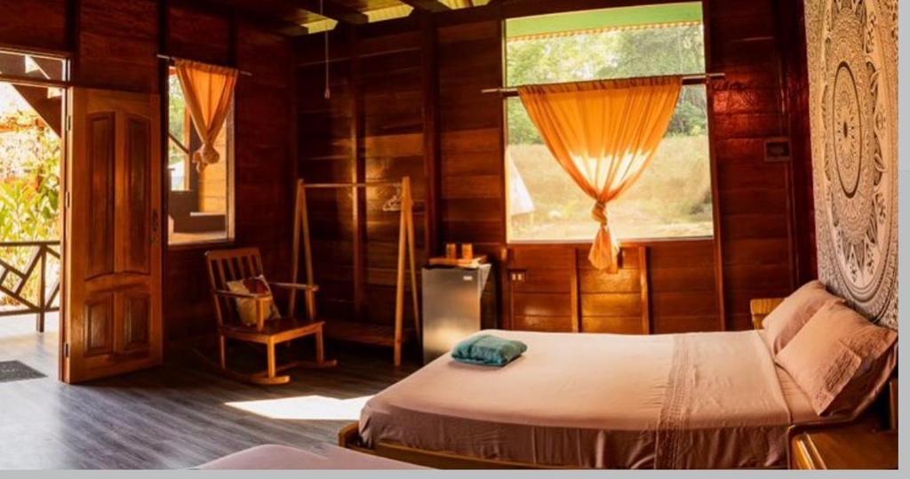 een slaapkamer met een bed, een raam en een stoel bij Aroldo Amazon Lodge in Puerto Maldonado