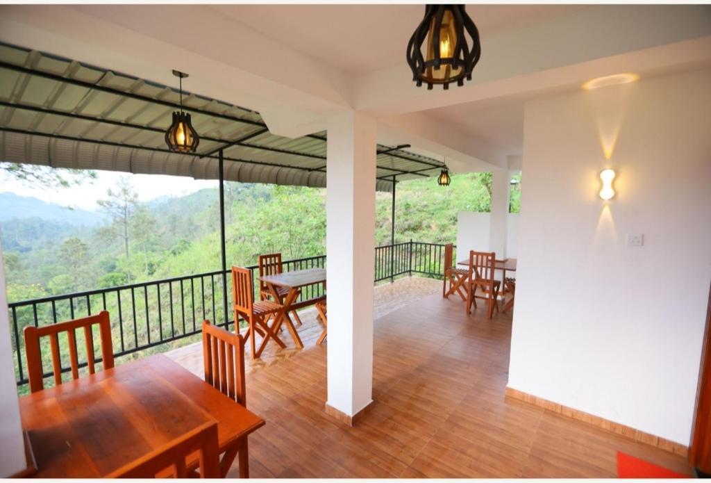 a dining room with a table and chairs on a balcony at Ella Ninestars Lodge in Ella