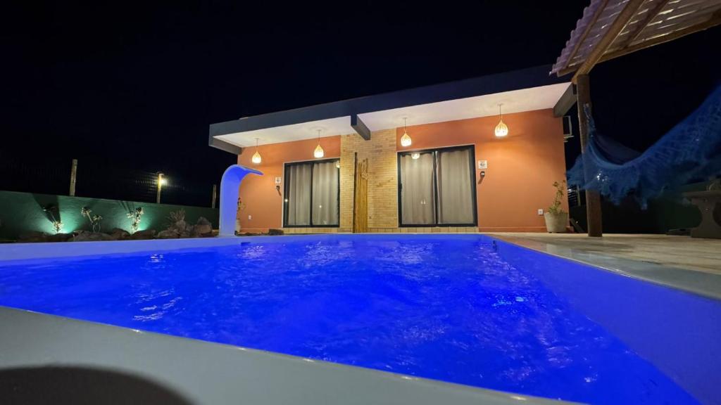 a swimming pool in front of a house at night at pipa paradise lofts in Tibau do Sul