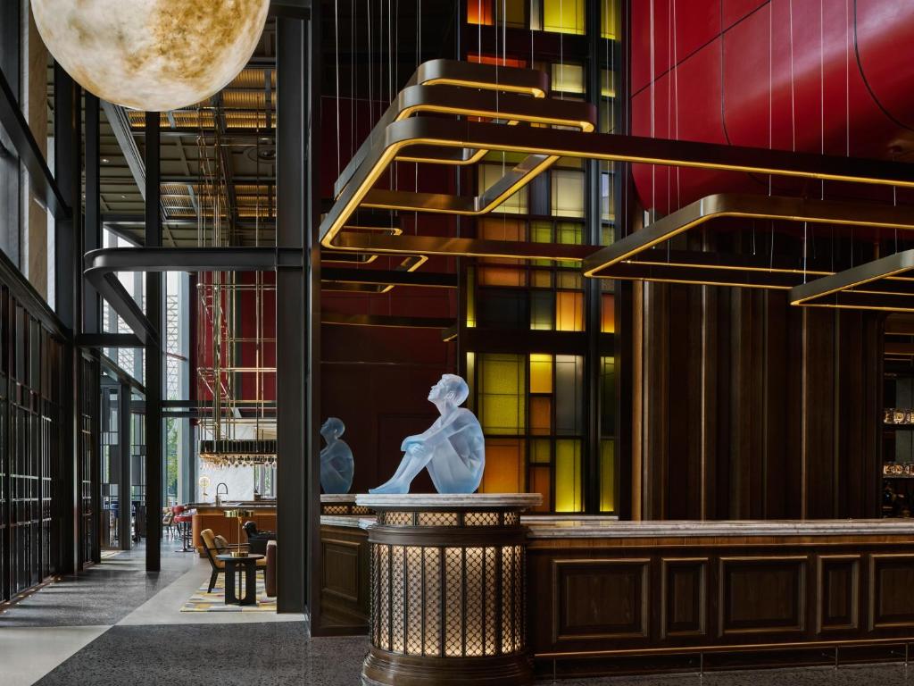 een lobby met een standbeeld in het midden van een gebouw bij Thompson Shanghai Expo in Shanghai