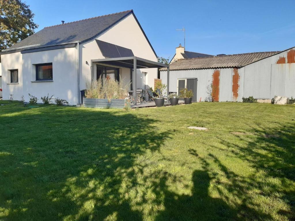 a white house with a large lawn in front of it at Cerillac in Questembert